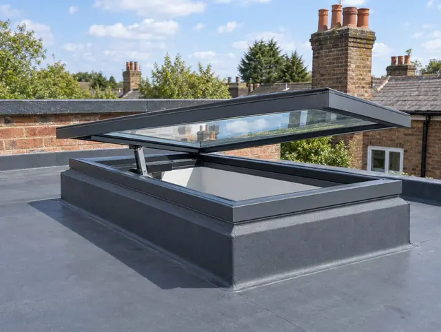 Electric opening flat rooflight hinged open on its actuator on a flat roof