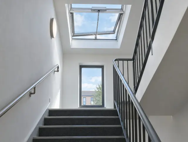 Automatic smoke vent rooflight partly open at the head of an apartment stairwell